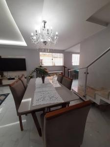 a dining room with a table and a chandelier at Casa para COP 30 in Belém +3 photos