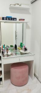 a glass display case with a pink stool under it at Casa para COP 30 in Belém