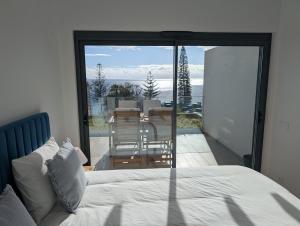a bedroom with a bed and a view of a patio at Breathtaking Oceanfront Living, Sunset Facing 3-Bedroom Flat in Acqua Residences in Funchal
