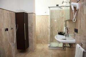 a bathroom with a sink, toilet and shower stall at 4 Spa Resort Hotel in Catania