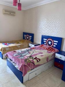 Un dormitorio con dos camas con sábanas del Capitán América. en single room shared bathroom, en El Cairo