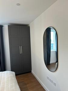 a bedroom with a mirror on the wall at Amazing 2 Bed Flat With City Views in Barking +3 photos