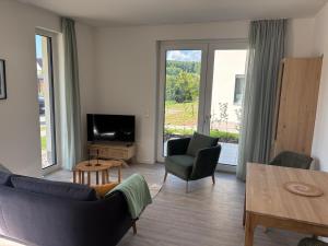 a living room with a couch and chairs and a television at Appartement Sonnenblume in Spangenberg