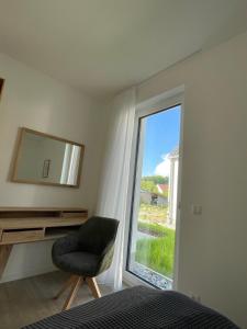 a bedroom with a chair and a mirror and a window at Appartement Sonnenblume in Spangenberg