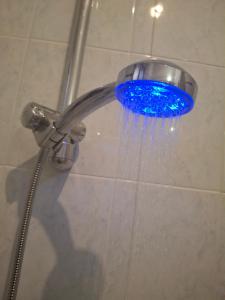 a shower with a blue shower head with water coming out at Heart of Verona in Verona +25 photos