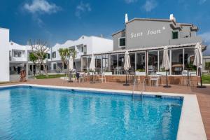 a pool in front of a hotel with a restaurant at Sant Joan Apartaments - Adults Only in Cala en Blanes