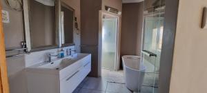 a white bathroom with a sink and a shower at Kleinmond Panorama Holidays in Kleinmond +59 photos