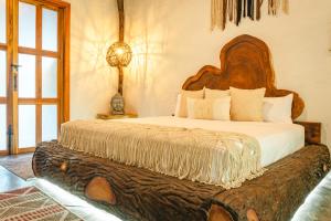 a bedroom with a large bed with a large wooden headboard at Anzalik Hotel Boutique in Anzá