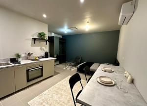 a kitchen and a living room with a table and chairs at Grand studio in Anthon