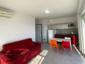 a living room with a red couch and orange chairs at BlueWaveapartments 2 in Shëngjin