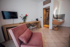a living room with a couch and a table with a television at Thirsty Dog Urban Port Studios in Igoumenitsa