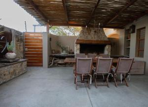 a patio with a table and chairs and a fireplace at Theebos in Strand