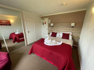 a hotel room with a bed with a red blanket at The Ashleigh in Paignton