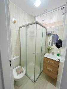 a bathroom with a shower and a toilet and a sink at Aconchegante apt Florença no centro com vaga coberta in Serra Negra +8 photos