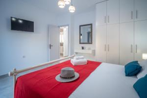 a white bed with a hat on top of it at Leros Houses Sea View 2 in Lépidha