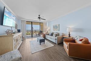 a living room with a couch and a flat screen tv at White Caps 102 in Orange Beach
