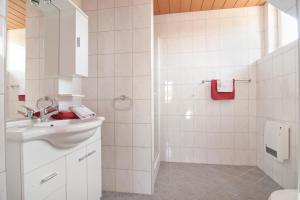 a white bathroom with a sink and a shower at Gästehaus Lutschounig in Faak am See