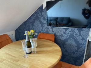 a wooden table with a bottle of wine and glasses at The Ashleigh in Paignton +40 photos