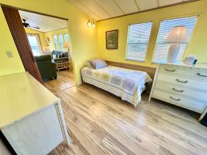 a small bedroom with a bed and a dresser at Beachfront Bliss N1026 in Jensen Beach +23 photos