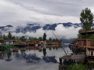 a view of a body of water with houses and mountains at New Dunhill Houseboat in Srinagar