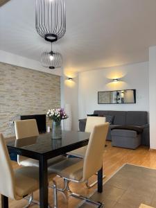 a dining room with a table and chairs at Comfortable Apartment in Cartier Evocasa Orizont Ploiesti (North) in Ploieşti