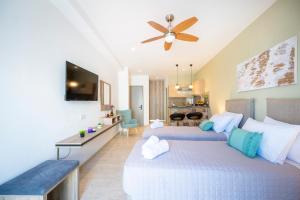 a bedroom with two beds and a ceiling fan at Diamond Apartments 4 in Kardamaina