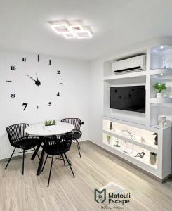 a dining room with a table and a clock on the wall at Matouli Escape in Philotium