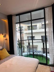 a bedroom with a large window with a view of a building at Stay In GAUTHIER studio s in Casablanca