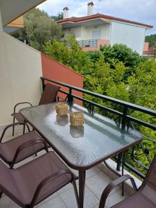 a glass table and chairs on a balcony at Nicholas House in Siviri