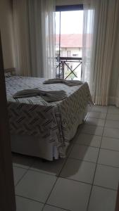 un letto in una stanza con una finestra di Flat Monte Castelo Gravatá - Apartamento 2 Quartos a Sairé Altre 84 foto