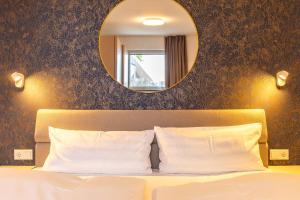 a bedroom with a bed with a mirror above it at Haus Anna Atelier in Ahrenshoop