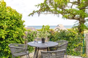 a patio with a table and chairs and the ocean at Haus Anna Atelier in Ahrenshoop +14 photos