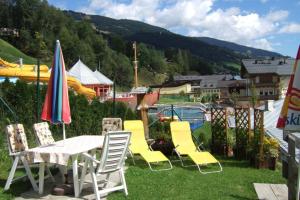 a group of chairs and a table and umbrella at MIMO Appartements in Saalbach-Hinterglemm