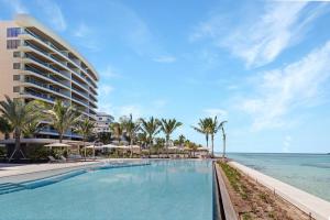 a large swimming pool next to the ocean at Beachfront 3 bedroom Luxury Residence in Nassau