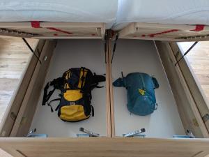 Una habitación con tres mochilas en la litera inferior de una tienda de campaña. en Apartmán A10 v centru Harrachova, en Harrachov 7 fotos más