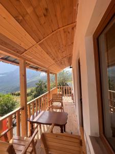 a wooden porch with a table and chairs on it at Lekbibaj view in Tropojë