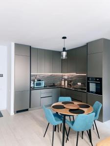 a kitchen with a wooden table and blue chairs at Herăstrău WIN Résidence No 4 in Bucharest