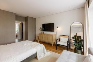 a bedroom with a bed and a chair and a mirror at NEST - Stometrivka in Ivano-Frankivsʼk