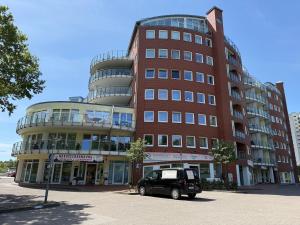 a car parked in front of a tall building at Haus Nordseebrandung FeWo C2 2 in Cuxhaven