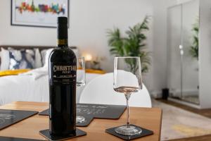 a bottle of wine and a glass on a table at City Centre Studio Apartments - Ashton Apartment - Short Stays UK Ltd in Exeter +9 photos