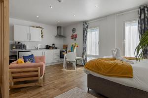 a bedroom with a large bed and a kitchen at City Centre Studio Apartments - Ashton Apartment - Short Stays UK Ltd in Exeter