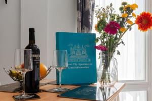 a bottle of wine and glasses on a table with flowers at City Centre Studio Apartments - Ashton Apartment - Short Stays UK Ltd in Exeter