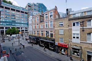 a city street with buildings and people walking on the street at Imperial Middlesex Street Apartments in London