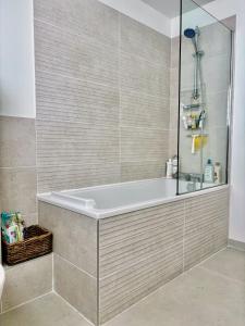 a bath tub in a bathroom with a shower at Jolie Chambre chaleureuse in Marseille