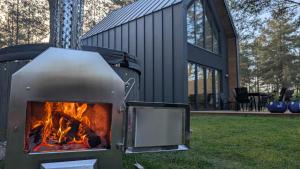 una griglia con un fuoco davanti a una casa di Sosnowy Raj Borsk a Borsk