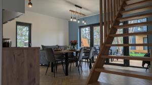 una cucina e una sala da pranzo con tavolo e sedie di Sosnowy Raj Borsk a Borsk