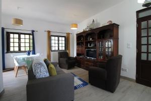 a living room with a couch and chairs and a table at Casa Morais in Vila Nova de Milfontes