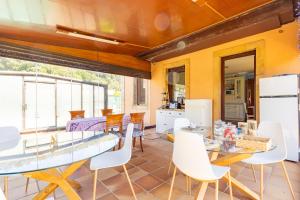 a dining room with a glass table and white chairs at villa dario in Argoños