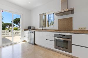 a kitchen with white cabinets and a view of the ocean at Villa Roco Marbella private pool and sea view in Marbella