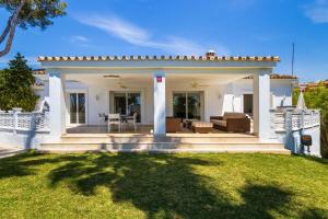 a white house with a white fence and a patio at Villa Roco Marbella private pool and sea view in Marbella